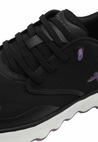 Schwarzer Sportschuh aus Mesh und synthetischen Materialien, mit runder Zehenpartie, Schnürsenkeln und kontrastierenden lila Akzenten an den Ösen und dem Logo.