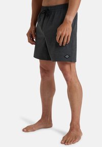 Pantaloni corti neri da uomo con vita elastica e cordino. Tessuto morbido e strutturato. Presenta un piccolo logo sulla gamba sinistra.