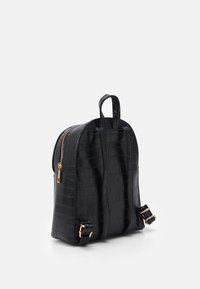 Czarny plecak ze wzorem skóry krokodyla o gładkiej powierzchni, z zamkiem błyskawicznym w złotym kolorze i regulowanymi paskami. Kompaktowy, zaokrąglony kształt z uchwytem u góry.