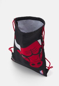 Sac cu șnur de culoare neagră, cu un design îndrăzneț al unei capete de taur roșu. Textură exterioară netedă, cu detalii din sfoară roșie și fermoar. Interiorul este gri.