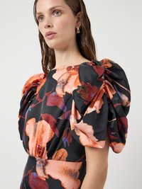 Floral puff-sleeve dress in black fabric adorned with vibrant orange and purple flower patterns, featuring a fitted waistline and smooth texture.