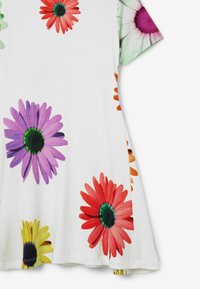 Top floreale caratterizzato da grandi margherite in rosa, rosso, viola e giallo su un tessuto a righe bianche. Maniche corte con dettagli floreali colorati.