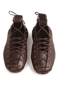 Chaussures en cuir marron avec un design unique à lacets et des œillets dorés, texture lisse. Construction à ouverture sur le dessus avec accents en tissu.