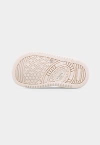 Σόλα παπουτσιού για νήπιο σε μπεζ χρώμα με σχεδιασμένα αντιολισθητικά πέλματα, μέγεθος 20 τυπωμένο και η λέξ η "short" ανάγλυφη στο κέντρο.