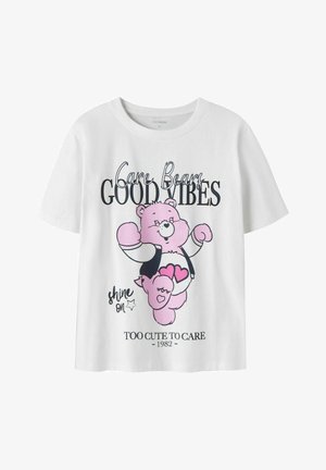 Witte T-shirt met roze Care Bear afbeelding en tekst "Care Bears Good Vibes," "shine on," en "Too Cute to Care 1982" op de voorkant.