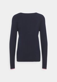 Námořnický svetr s dlouhým rukávem a kulatým výstřihem, s pružnými manžetami, bočními prošitími a kontrastním barevným akcentem na lemu. Hladká pletená textury.