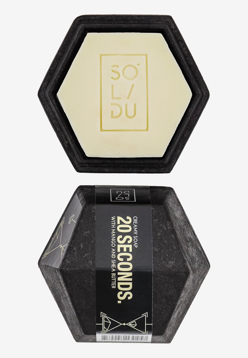 Hexagonal soap in cream with a black base. Label in black with gold text stating "20 SECONDS." Features decorative geometric accents.
