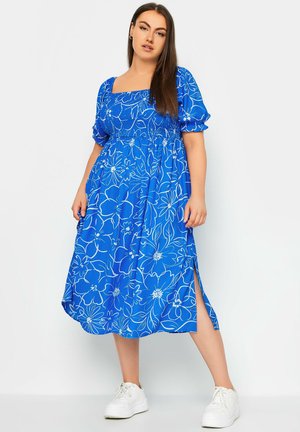 Blauwe bloemen midi jurk met korte pofmouwen en een vierkante halslijn, met een gerimpelde lijfje en zijsplitten. Gekocht met witte sneakers.