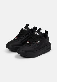 Baskets de sport noires avec une tige synthétique lisse, des accents texturés, un système de laçage et une semelle en caoutchouc épaisse et rembourrée. Logo Fila sur la languette.