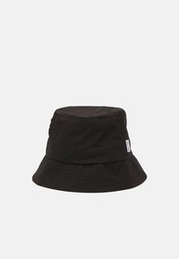 Svart bøttehatt laget av lett materiale, med avrundet topp, bred brem og subtil tekstiltekstur med en liten etikettdetalj.
