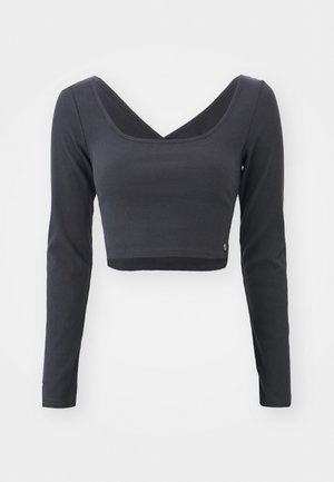 Langærmet, cropped top i mørkegrå ribbet stof. Har en dyb V-halsudskæring og ensfarvet med et lille logo ved sømmen.
