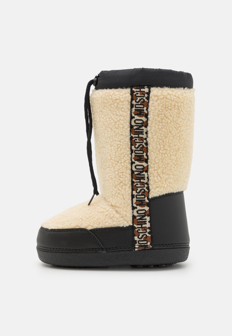 Αμυδρό κρεμ και μαύρο μποτίνι μέχρι τον αστράγαλο με υφή, που διαθέτει διακοσμητική λωρίδα και κλείσιμο με κορδόνι για σφιχτό κράτημα.