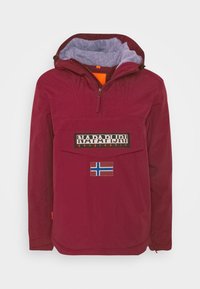 Giacca con cappuccio color marrone bordeaux, con collo con zip, fodera in pile, grande tasca frontale, patch con marchio e dettaglio della bandiera norvegese. Tessuto liscio e leggero.