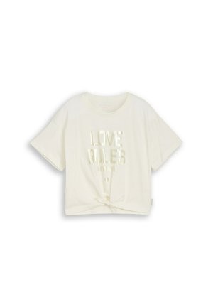 Cream-colored short-sleeve T-shirt with front knot and shiny text "LOVE RULES ALWAYS" on the chest.