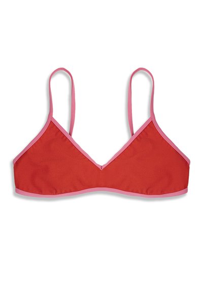 Haut court rouge en forme de triangle avec de fines bretelles roses et un bord rose autour des contours, posé à plat sur un fond blanc.