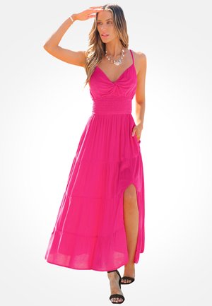 Abito maxi rosa con design a strati, corpetto aderente e spacco laterale. Realizzato in un tessuto leggero, presenta una vita arricciata e spalline sottili.