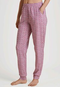 Roze geprinte pyjamabroek met witte bloemenpatronen, elastische tailleband, zijzakken, taps toelopende benen en omgeslagen boorden. Zacht, lichtgewicht stof.