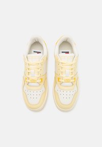 Sneakers bianche e giallo tenue con tomaia in pelle liscia, lingua imbottita, lacci tono su tono e dettagli a contrasto. Caratterizzate da dettagli traforati.