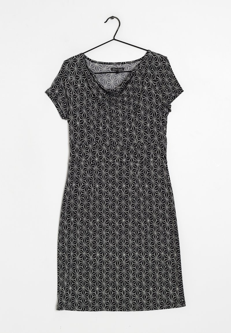 Schwarzes Kleid mit taillierter Passform, kurzen Ärmeln und floralen Mustern aus weißen Formen, das an einem schwarzen Plastikbügel hängt.