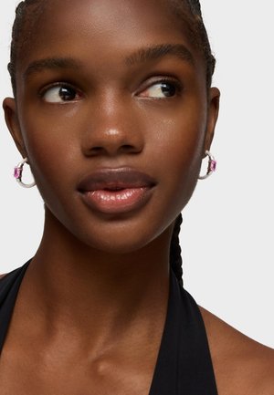 Orecchini a cerchio in argento con un accento di pietra rettangolare rosa, caratterizzati da una superficie texture e una chiusura a clip sicura.