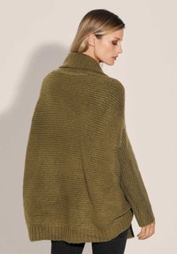 Olivgrüner Strickpullover mit weitem Kragen, offenen Seiten und geripptem Saum. Strukturierter Stoff mit einer lockeren, übergroßen Passform.