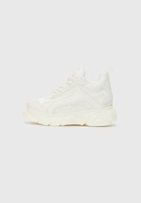 Sneaker blanc en matériau synthétique texturé, à semelle épaisse et design à lacets. Présente un logo subtil sur le côté et une pointe arrondie.