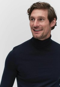 Marineblauwe coltrui in een aansluitend ontwerp, gemaakt van een zachte stof, met een geribbelde kraag en een gladde textuur, voorzien van lange mouwen.