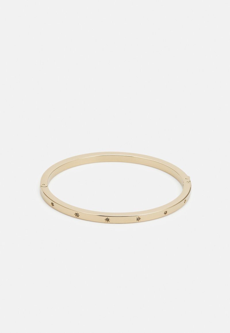 Bracelet jonc en métal doré avec une forme épurée, agrémenté de petits détails en forme d'étoile répartis uniformément autour du bracelet.