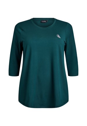 T-shirt à manches longues pour femmes en vert sarcelle avec un col rond et un petit logo géométrique blanc sur la poitrine gauche.