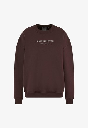 Brun sweatshirt med rund halsudskæring, lange ærmer og ribstrikkede manchetter. Teksten på frontlogoet læser "Aim'n Sportswear Sweden New Zealand 2013."
