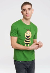 Green cotton t-shirt featuring a cartoon bee design with a smiling face, black stripes, and a red accent on its head. Casual fit.