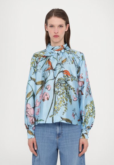 Blusa di seta azzurra chiara con motivi floreali in rosa, arancione e verde; presenta un collo alto e maniche ampie, leggermente arricciate sulle spalle.