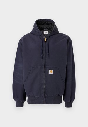 Sudadera con cremallera color azul marino, hecha de algodón, con un interior acolchado, cordones en la capucha y un parche de logo en la parte delantera.