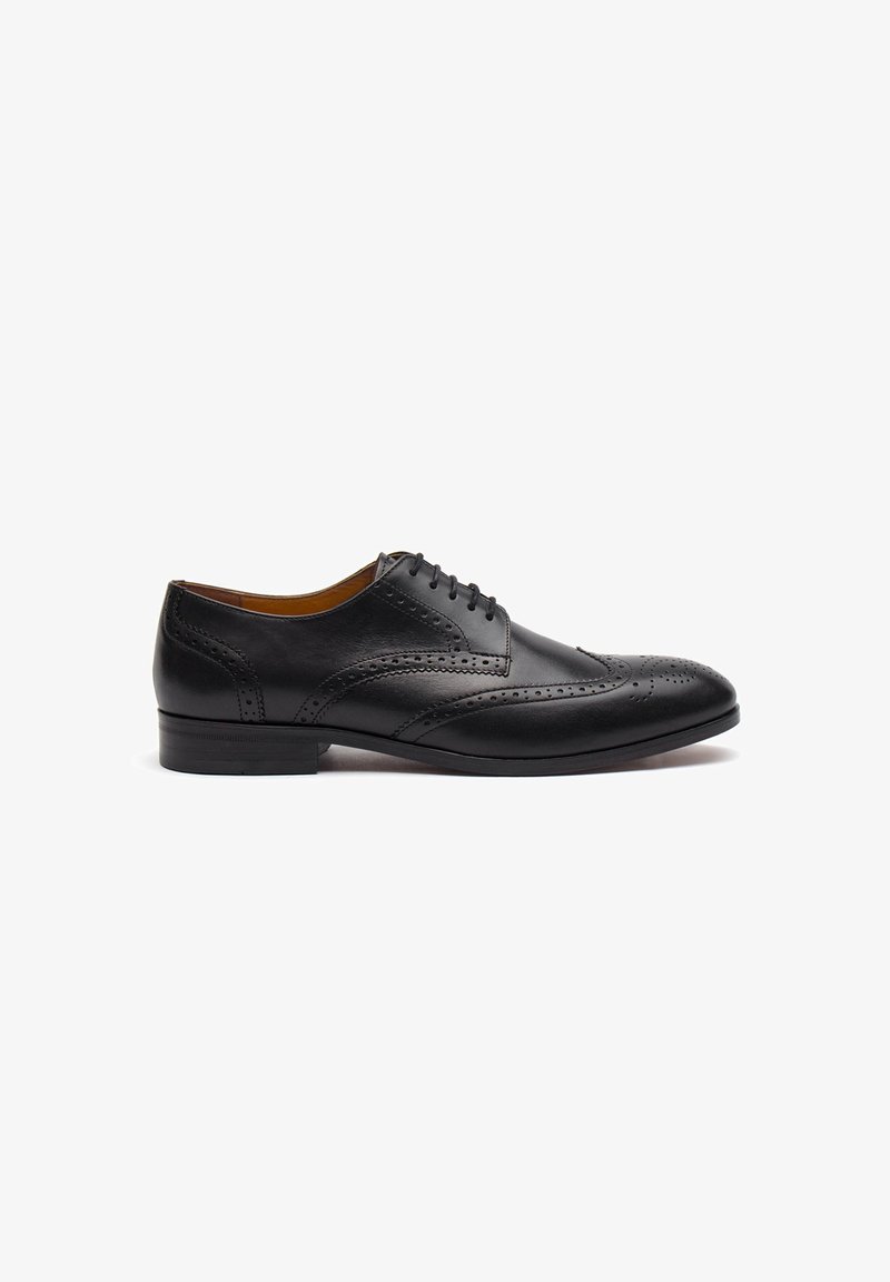 Scarpe da uomo in pelle nera con dettagli brogue, chiusura con lacci, punta arrotondata e tacco basso, ideali per abbigliamento formale.