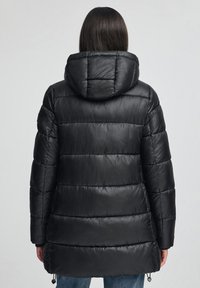 Svart puffjacka med huva, med quiltade sektioner, justerbara dragsnören vid fållen och en slät, blank yta.