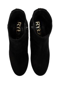 Czarne zamszowe botki za kostkę o gładkiej teksturze, z bocznymi zamkami błyskawicznymi i zaokrąglonym noskiem. Złote logo widoczne wewnątrz.