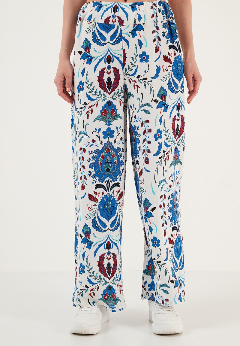 Losse, witte broek met bloemenpatroon in blauwe, rode en groene accenten; elastische tailleband; lichtgewicht stof; rechte pijpen.