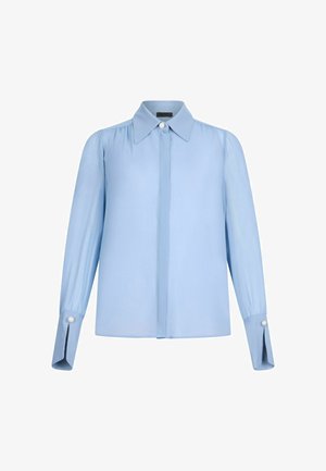 Hele sinine pluus pehmest kangast, millel on terav krae, nööpidega kinnitamine ning pärlitetušo üle õlgade, relaxed-fit mudel.