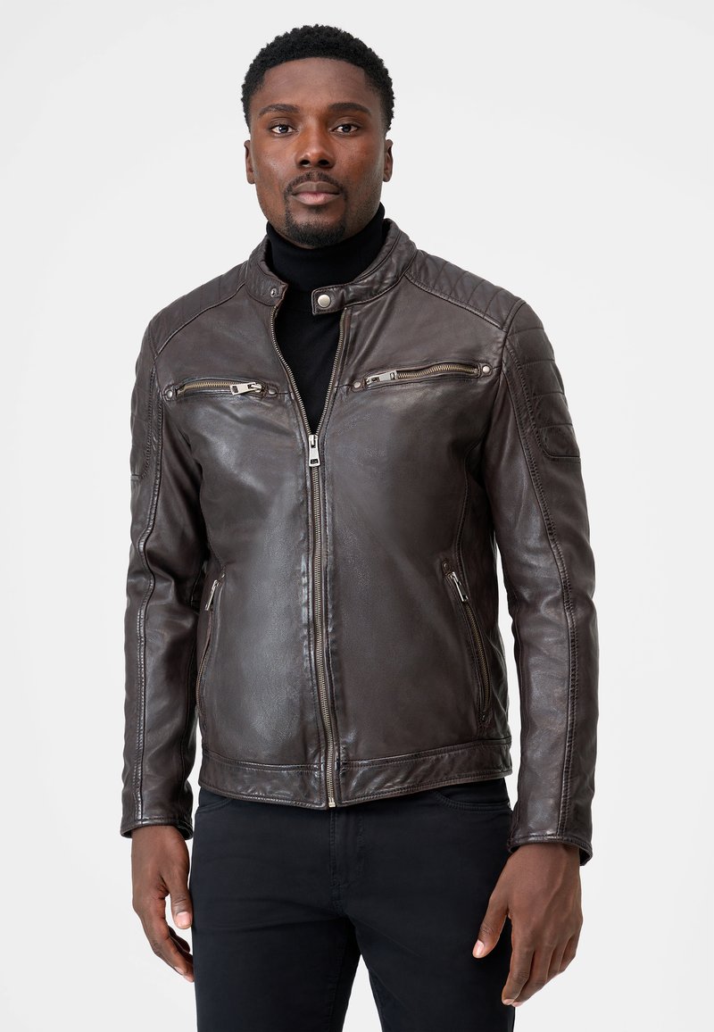 Braune Leder-Motorradjacke mit einem gesteppte Design, ausgestattet mit zwei Reißverschlusstaschen auf der Brust und Seitentaschen. Glatte Textur und taillierte Passform.