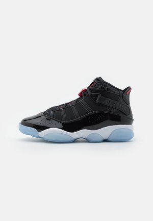 Czarny, wysokostronny sneaker do koszykówki z detalami z lakierowanej skóry, czerwonymi akcentami, paskiem z napisem „Air Jordan” oraz przezroczystą lodowoniebieską podeszwą.