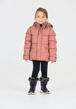 Veste rose bouffante avec capuche, leggings noirs et bottes d'hiver noires avec des motifs floraux et des bordures en fourrure.