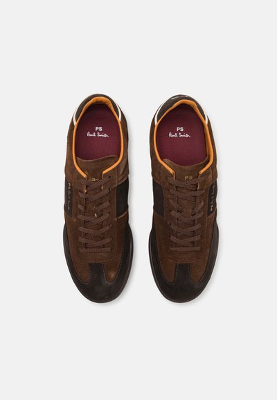 Brown suede sneakers with dark accents, round toe, flat laces, orange lining, and branded insole. Features a textured surface and smooth sole.