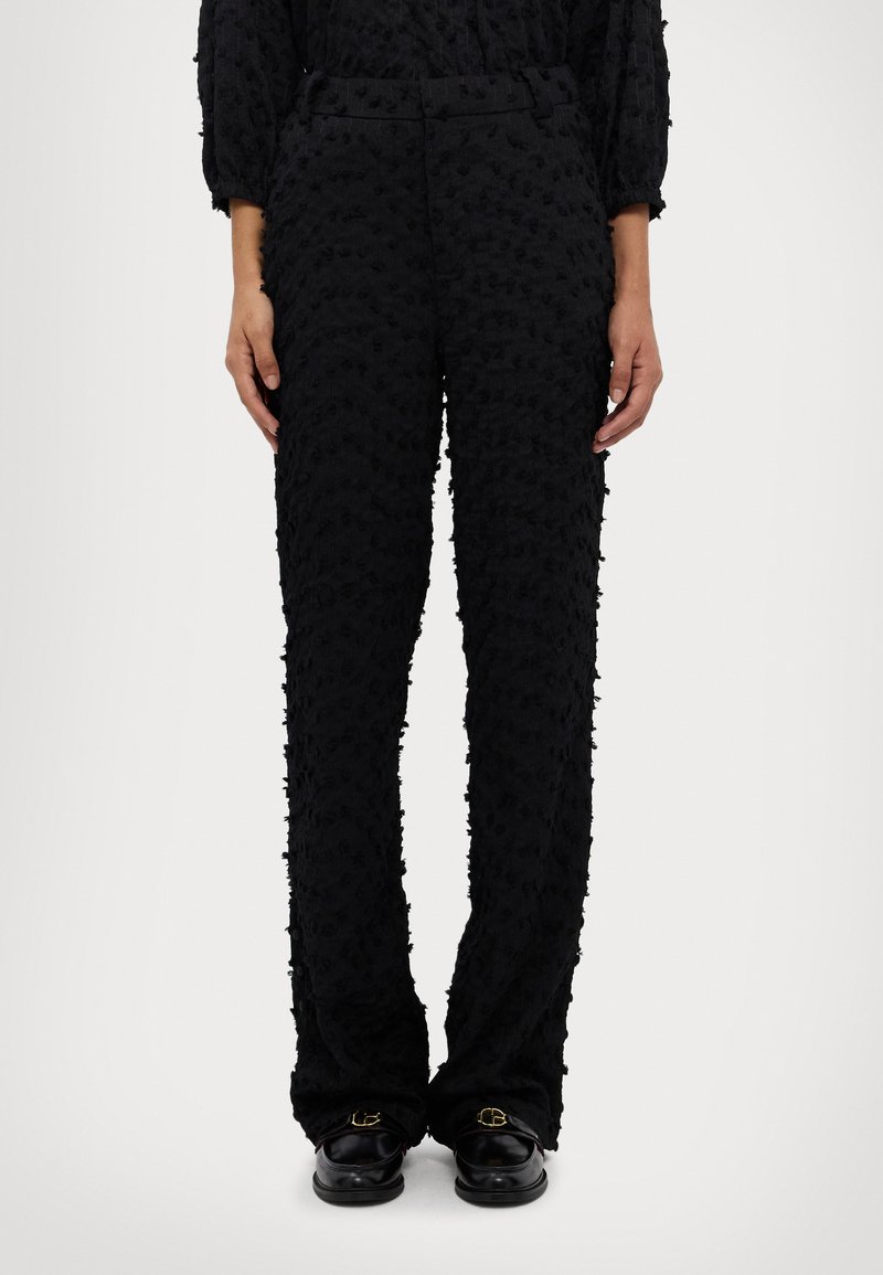 Black pants with a textured pattern, featuring a high waist and straight legs. The fabric appears soft with a subtle raised motif.