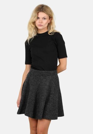 Svart kortermet topp kombinert med en mørkegrå ribbet skjørt med utforming, som har et teksturert stoff og en bred midjebånd.