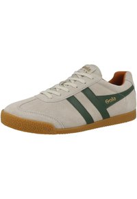 Sneaker in suede beige chiaro con strisce in pelle verde, suola in gomma, design con lacci e dettaglio del logo dorato sul lato.
