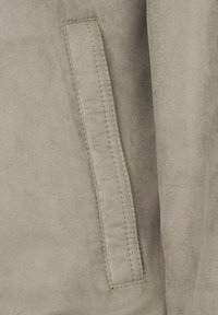 Light gray suede fabric close-up featuring a stitched pocket detail. The texture appears soft with matte finish and clean edges.