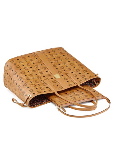 Bruine leren designer tote bag met zwart logo patroon, dubbele handvatten, een afneembare pouch binnenin en een geometrische voering in rood, wit en zwart.