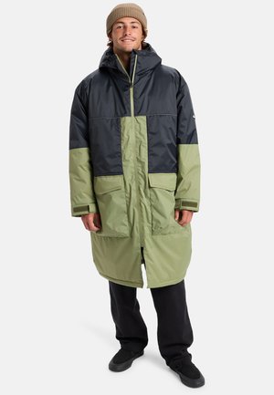 Manteau en duvet avec un design bicolore ; partie supérieure bleu marine foncé et partie inférieure olive clair. Présente une capuche, une fermeture éclair et des poches avant.