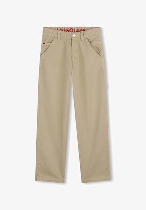 Pantalon beige à coupe droite, fabriqué en tissu de coton. Dispose de poches avant et d'un logo rouge à l'intérieur de la ceinture.