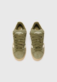 Sneaker in suede verde con dettagli bianchi, punta tonda, suola piatta in gomma e lacci tondi. Logo sulla linguetta, colletto imbottito per il comfort.